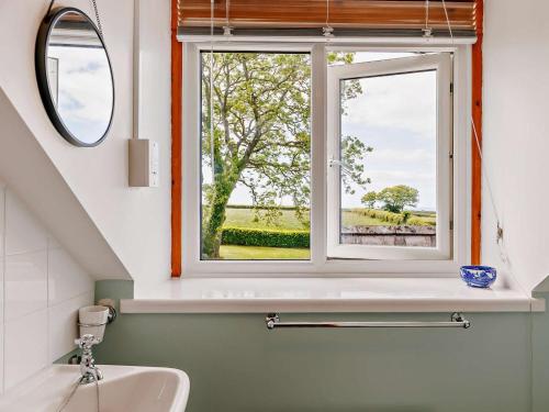 a bathroom with a sink and a window at 4 Bed in Llanrhystud oc-92072 in Llanrhystyd