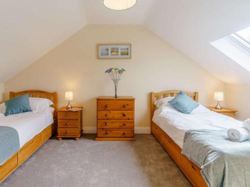 two twin beds in a attic bedroom with two lamps at 2 Bed in Lampeter oc-86507 in Cellan