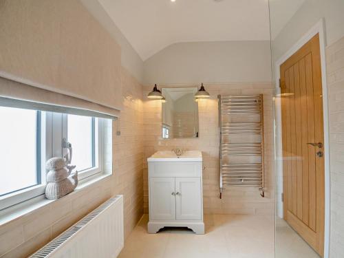 a bathroom with a sink and a mirror at 3 Bed in Pwllheli oc-95040 in Morfa Nefyn