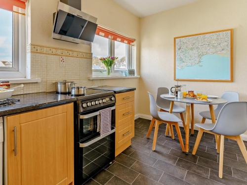 a kitchen with a table and a stove top oven at 2 Bed in Saundersfoot oc-74356 in Saundersfoot