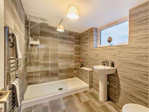 a bathroom with a tub and a sink and a toilet at 4 Bed in Cardigan oc-94137 in Aberporth