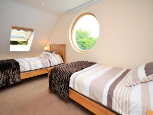 a bedroom with two beds and a round window at 3 Bed in Narberth oc-36799 in Llawhaden