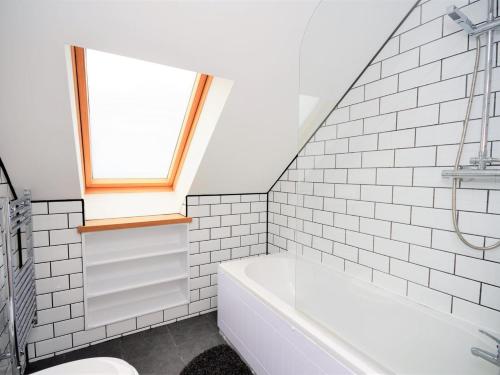 a bathroom with a white tub and a window at 3 Bed in Narberth oc-36799 in Llawhaden