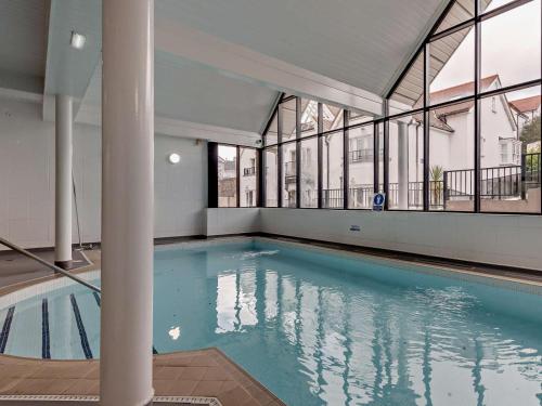 a large swimming pool in a building with windows at 2 Bed in Tenby oc-fb032 in Tenby