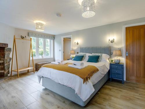 a bedroom with a large bed with blue accents at 1 Bed in Presteigne oc-78351 in Kinsham