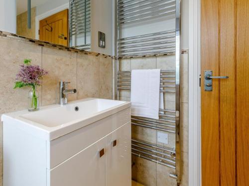 a bathroom with a white sink and a mirror at 1 Bed in Presteigne oc-78351 in Kinsham