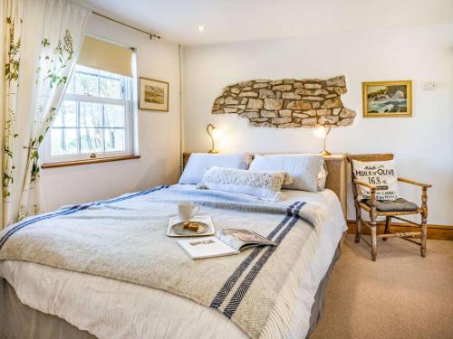 a bedroom with a large bed with a stone wall at 3 Bed in Bridgend oc-57715 in Southerndown
