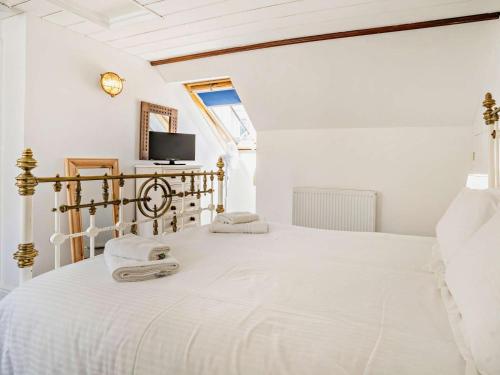 a white bedroom with a bed with towels on it at 1 Bed in New Quay oc-45927 in New Quay