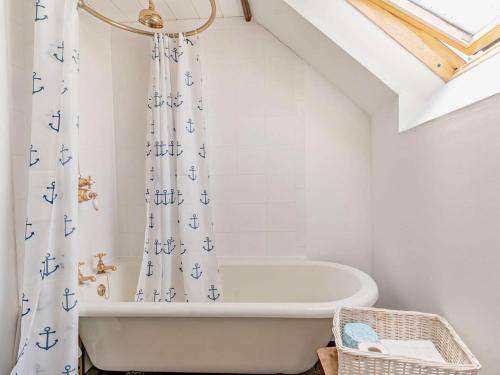 a bathroom with a tub and a shower curtain at 1 Bed in New Quay oc-45927 in New Quay