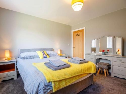 a bedroom with a bed with a yellow blanket at 3 Bed in Fairbourne oc-86841 in Fairbourne