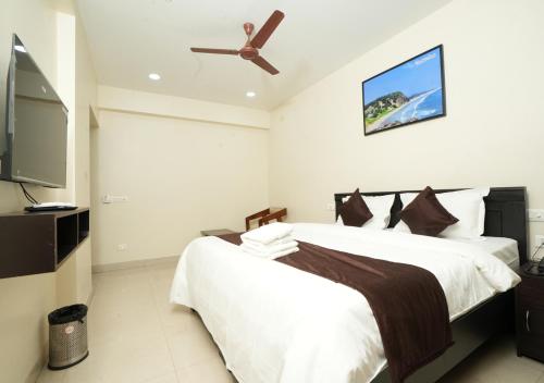 a bedroom with a bed and a ceiling fan at ADITYA BEACH SUITES in Visakhapatnam