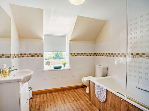 a bathroom with a tub and a toilet and a sink at 1 Bed in Swansea oc-52906 in Llanrhidian
