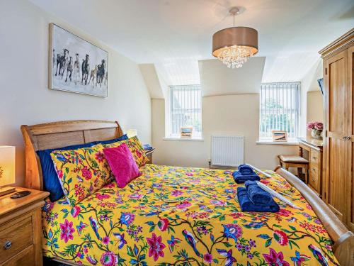 a bedroom with a bed with a colorful blanket at 1 Bed in Swansea oc-52906 in Llanrhidian