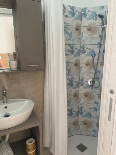 a bathroom with a shower curtain and a sink at Acrita Superior in Mandaradoni