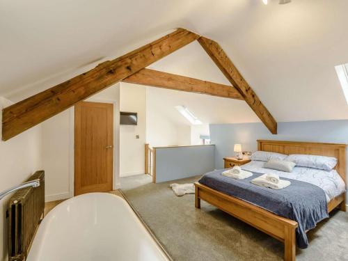 a attic bedroom with a bed and a bath tub at 1 Bed in Llanrwst oc-83950 in Llanrwst