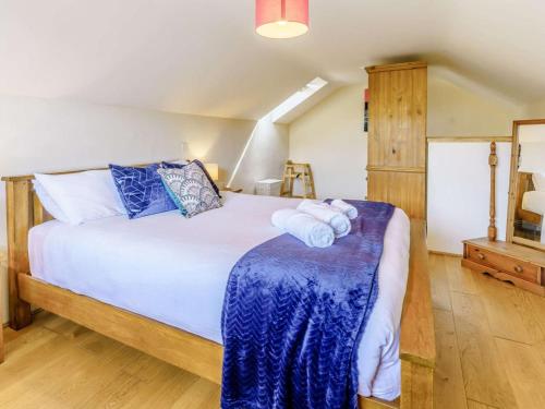 a bedroom with a large bed with blue pillows at 2 Bed in Aberaeron oc-45333 in Aberaeron