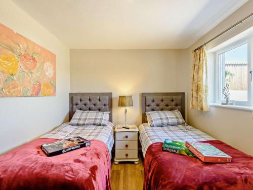 a bedroom with two beds and a window at 2 Bed in Holyhead oc-81515 in Caeʼr-geiliog