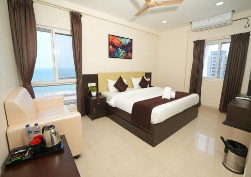 a bedroom with a bed and a desk and a couch at ADITYA BEACH SUITES in Visakhapatnam