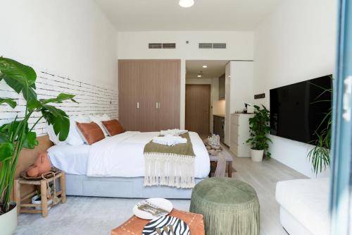 a bedroom with a large bed and a living room at Luxurious Studio Hidden Condo In Dubai in Dubai