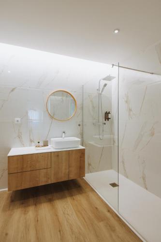 a white bathroom with a sink and a mirror at Casa D'Almo in Almograve