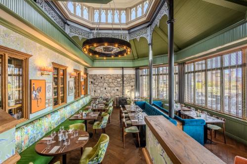 a restaurant with tables and chairs and windows at Palm Court Hotel in Aberdeen