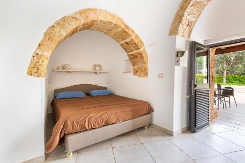 a bedroom with a bed and an archway at Trulli degli Augelli by BarbarHouse in San Michele Salentino