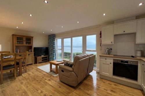 a living room with a kitchen and a dining room at Cliffside Garden Flat in Woolacombe