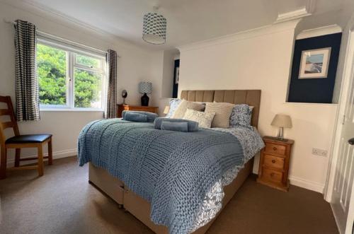 a bedroom with a bed with a blue comforter at Cliffside Garden Flat in Woolacombe
