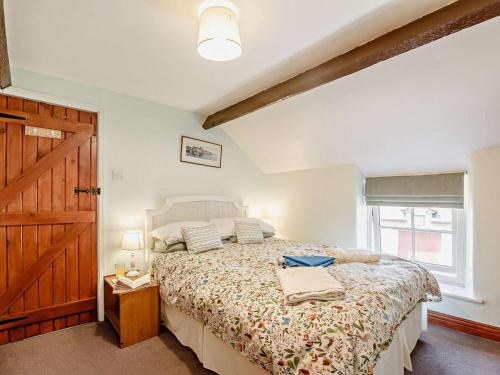 a bedroom with a bed and a wooden door at 2 Bed in Colwyn Bay oc-50933 in Eglwys-Fâch