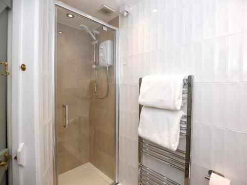 a bathroom with a shower with a glass door at 3 Bed in Conwy oc-tygos in Llangelynin