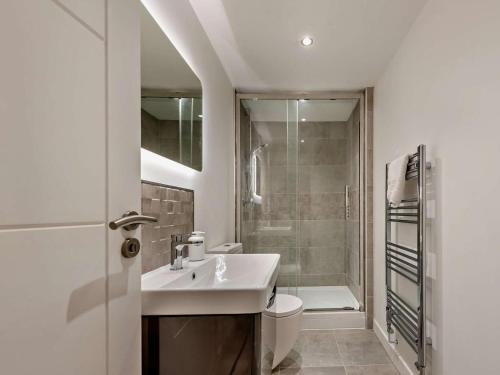 a bathroom with a sink and a toilet and a shower at 4 Bed in Llandovery oc-90307 in Myddfai