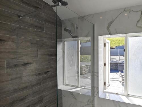 a bathroom with a glass shower with a window at 3 Bed in Aberaeron oc-95971 in Aberaeron