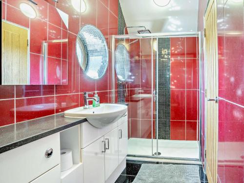 a red bathroom with a sink and a shower at 1 Bed in Narberth oc-72867 in Whitland