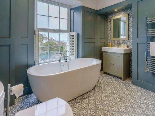 a bathroom with a tub and a sink and a window at 3 Bed in New Quay oc-83998 in New Quay