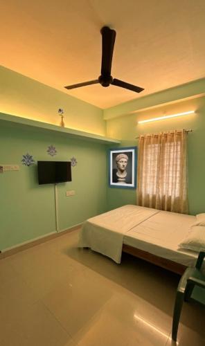 a bedroom with a bed and a ceiling fan at STAR Residency - G in Pondicherry
