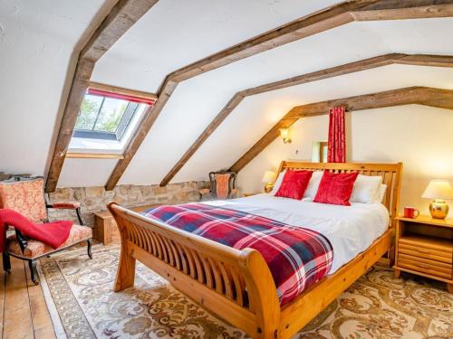 a bedroom with a wooden bed with red pillows at 1 Bed in Swansea oc-77981 in Penclawdd