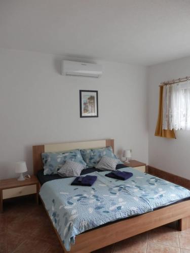 a bedroom with a bed with a blue comforter at Guest House Tiho in Silba