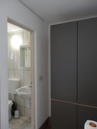 a bathroom with a sink and a toilet and a mirror at Guest House Tiho in Silba