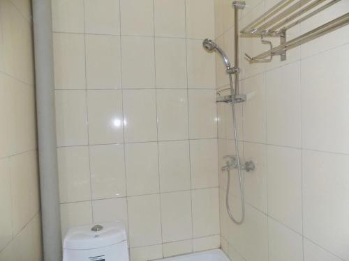 a white bathroom with a shower and a toilet at Hotel Shine Sunet in Mbarara