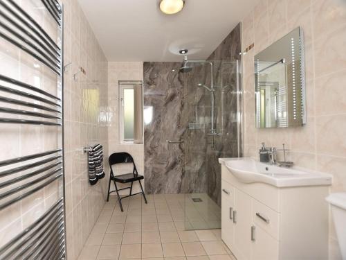 a bathroom with a sink and a shower and a chair at 2 Bed in Bala oc-86964 in Llandderfel