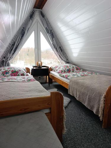 two beds in a room with a window at Zawojskie Spanie in Zawoja