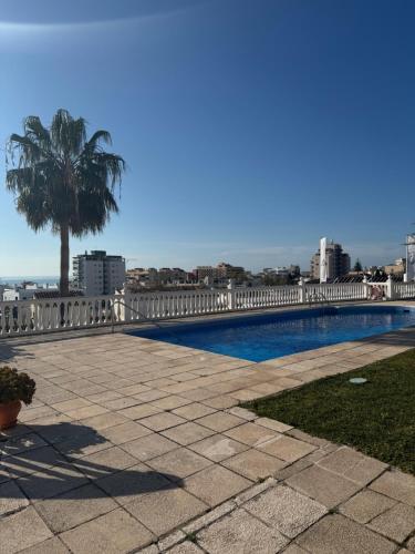 una piscina con una palma sullo sfondo di Apartaments Bastion a Torremolinos
