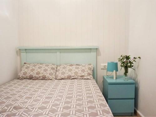 a bedroom with a bed and a blue nightstand with a bed sidx sidx sidx at Cas Bufador in Sa Coma