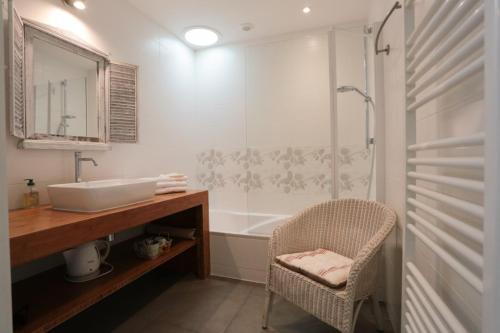 a bathroom with a sink and a shower and a chair at Kerlenn in Baden