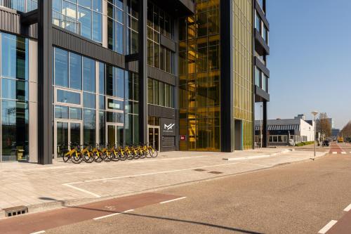 a large building with bikes parked outside of it at Makerstoren Short stay serviced apartments for 28 to 180 days in Amsterdam