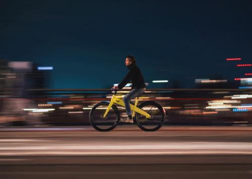 a man riding a yellow bike down a street at Makerstoren Short stay serviced apartments for 28 to 180 days in Amsterdam