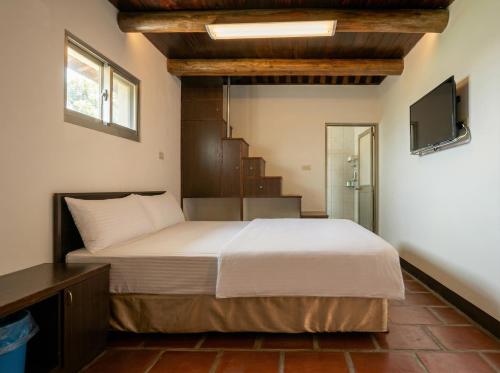 a bedroom with a bed and a television in it at Zhong Lan Homestay in Chung-lan