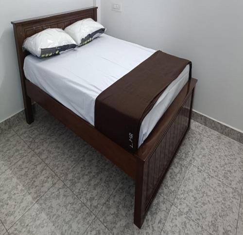 a large bed with white sheets and pillows on it at Landmark Residency in Atirāmpattinam