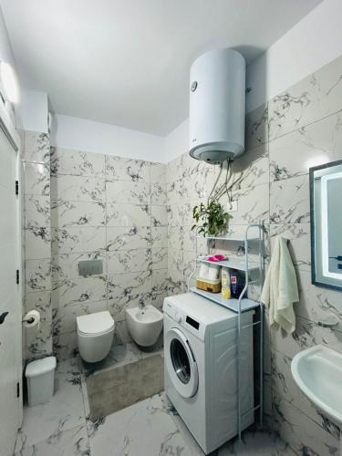 a bathroom with a washing machine and a sink at Sunset Apartment in Orikum