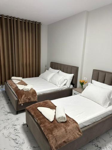 two beds in a hotel room with towels on them at Sunset Apartment in Orikum